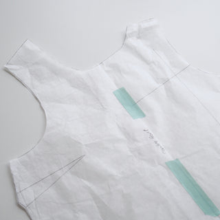White fabric with blue tape markings on a gray background