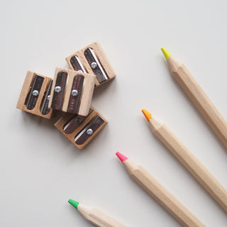 Colorful pencils with wooden sharpeners on a light gray background